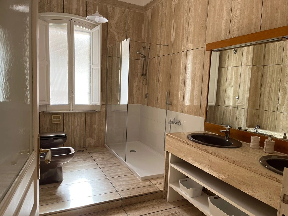 Spacious bathroom in travertine with walk-in shower