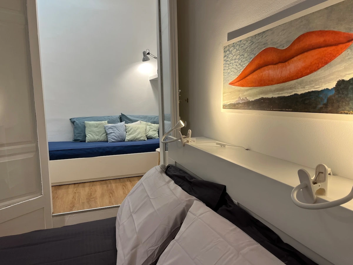 Bedroom detail with reading lamps and artwork