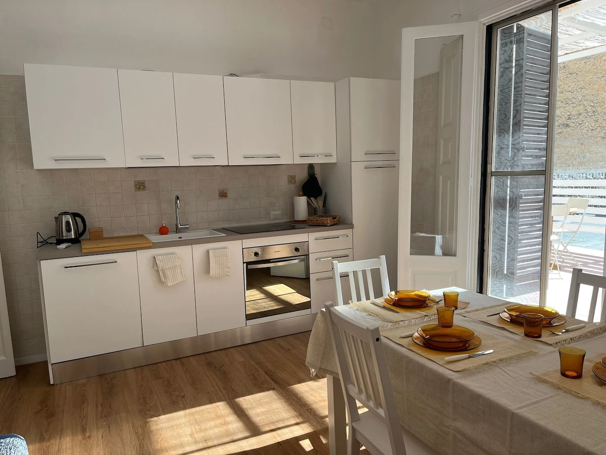 Modern white kitchen opening onto the terrace