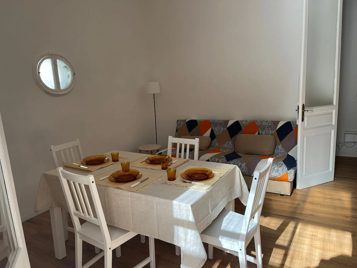Bright living and dining area with a sofa and set table